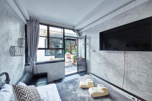 a room with a tv and a bed and a couch at Goodnight hotel in the ancient Hutong in Beijing