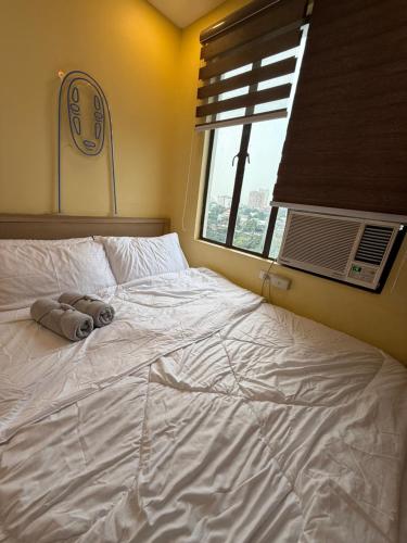 a large white bed in a bedroom with a window at Elly's Place in Quezon City