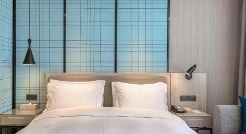 a bedroom with a large bed with white pillows at Echarm Hotel Kunming High-speed Railway South Station Chunrong Street Metro Station in Kunming