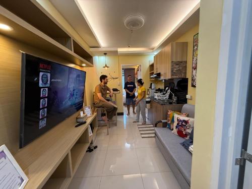 a group of people in a living room with a large tv at Elly's Place in Quezon City