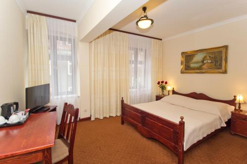 a bedroom with a bed and a desk with a computer at Hotel Retman in Toruń