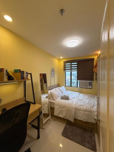a bedroom with a bed and a desk in it at Elly's Place in Quezon City