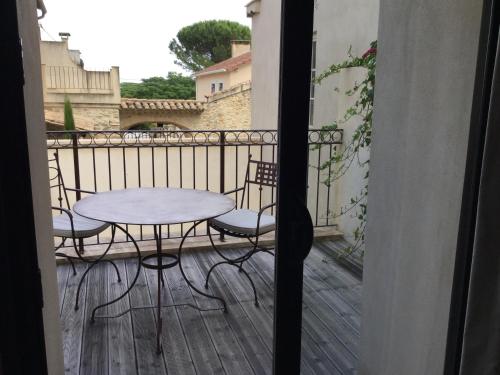 a patio with a table and chairs on a balcony at Boutique Hôtel La Villa MONTESQUIEU in Laudun