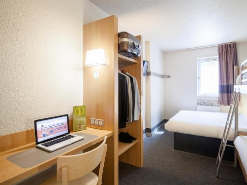 a room with a desk with a laptop and a bed at B&B HOTEL Marne-la-Vallée Bussy-Saint-Georges in Bussy-Saint-Georges