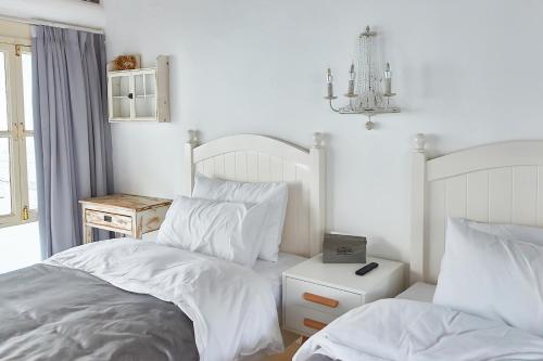 a bedroom with two beds with white sheets and a chandelier at Goodnight hotel in the ancient Hutong in Beijing