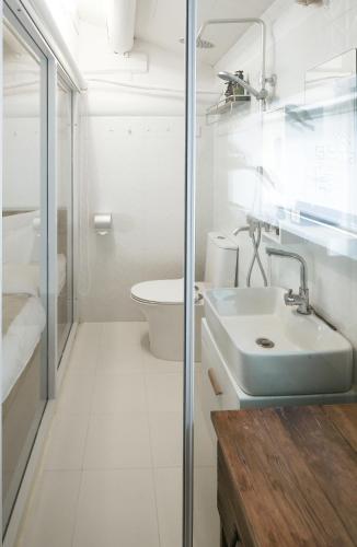 a white bathroom with a sink and a toilet at Goodnight hotel in the ancient Hutong in Beijing