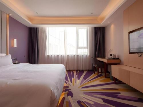 a hotel room with a bed and a desk and a television at Lavande Hotel Changsha South High-speed Railway Station Xiyingmen in Changsha