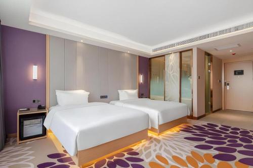 a bedroom with two beds and a room with a rug at Lavande Hotel Changsha South High-speed Railway Station Xiyingmen in Changsha