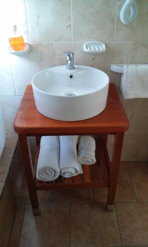 a white sink on a wooden table in a bathroom at Piedra Caliza in Tandil