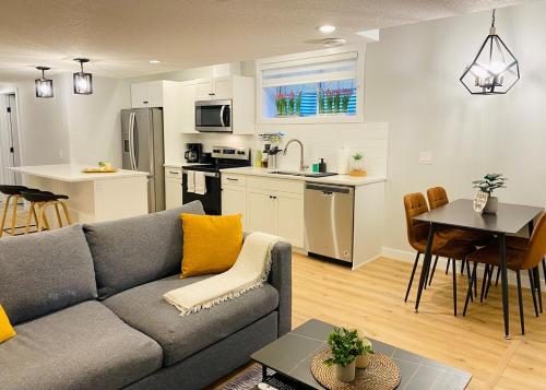 a living room and kitchen with a couch and a table at The Private Central Edmonton Suite - Comfortable & Fully-Equipped Basement Suite in Edmonton