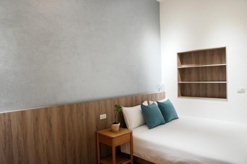 a bedroom with a white bed with blue pillows at 循跡文旅 Tracöver 