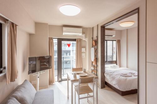 a bedroom with a bed and a desk with a television at Hostel Inn Tokyo Asakusa Annex in Tokyo
