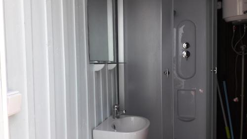 a white bathroom with a sink and a mirror at Poilsiavietė Mano Maljorka in Šventoji