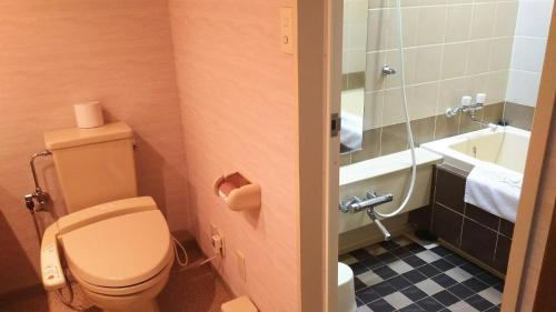 a bathroom with a toilet and a bath tub at Furano Hops Hotel - Vacation STAY 41210v in Kami-furano