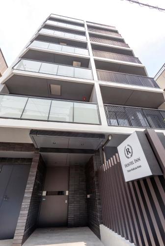 a tall building with a sign in front of it at Hostel Inn Tokyo Asakusa Annex in Tokyo