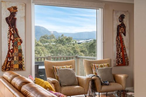 a living room with a couch and a large window at Golf & Wine Country Villa Cypress in Pokolbin
