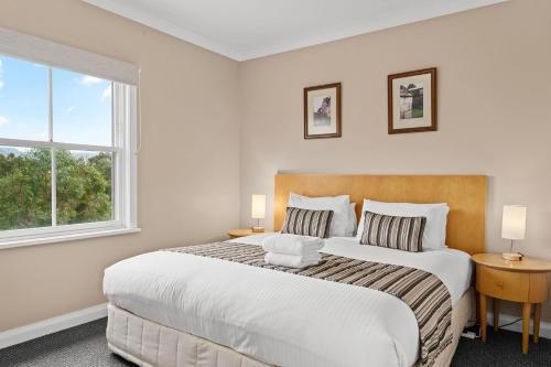 a bedroom with a large bed and a window at Golf & Wine Country Villa Cypress in Pokolbin