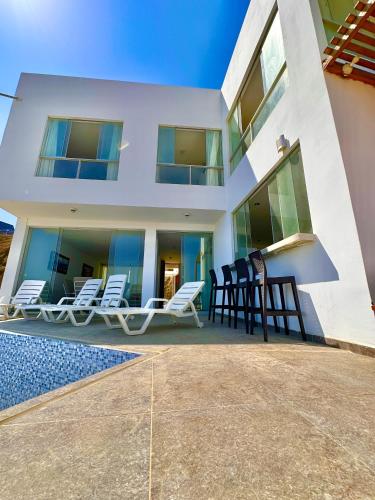 a group of chairs sitting outside of a house at Casa Bahía El Ñuro in El Ñuro