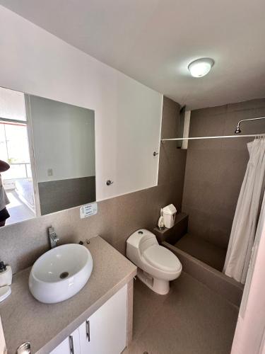 a bathroom with a sink and a toilet and a mirror at Casa Bahía El Ñuro in El Ñuro