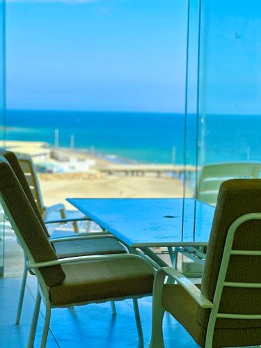 a table and chairs with a beach in the background at Casa Bahía El Ñuro in El Ñuro