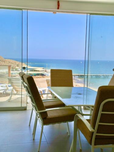 a table and chairs with a view of the beach at Casa Bahía El Ñuro in El Ñuro