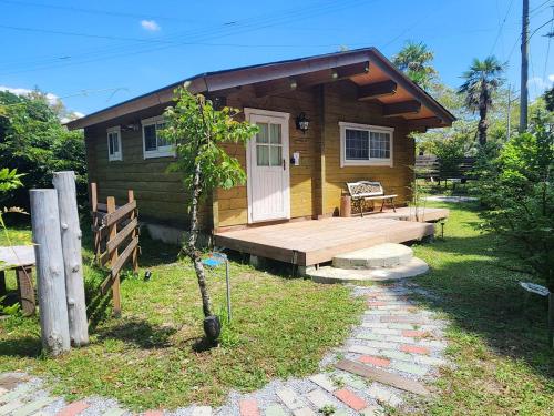 a small cabin with a porch and a deck at 藤のヴィラ オリーブ棟 Self check-in in Aso