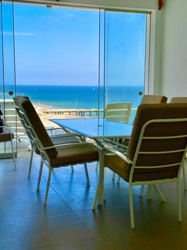a table and chairs with a view of the beach at Casa Bahía El Ñuro in El Ñuro