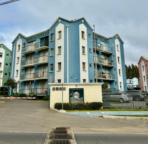 a large blue and white apartment building with a parking lot at Algarrobo descanso junto al mar in Mirasol
