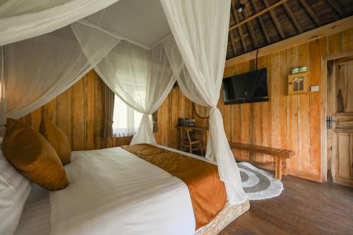 a bedroom with a bed with a canopy at Keuma Villa & Resto Jatiluwih by The Lavana in Jatiluwih