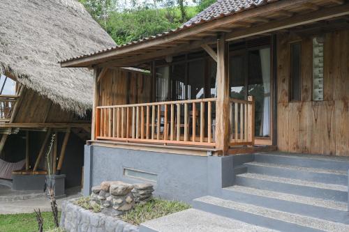 a house with a thatch roof and stairs in front at Keuma Villa & Resto Jatiluwih by The Lavana in Jatiluwih