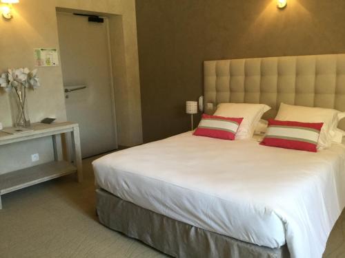 a bedroom with a large white bed with two pillows at Boutique Hôtel La Villa MONTESQUIEU in Laudun