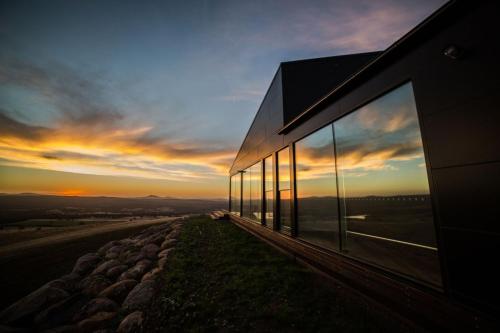 a building with glass windows on the side of it at Sky High- iconic ridge-top retreat in Hepburn Springs