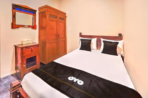 a bedroom with a bed with a dresser and a mirror at OYO 94769 Griya Djati Syariah 2 in Malang