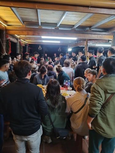 a large group of people sitting at tables in a room at Homestay Tommy House in Ha Giang
