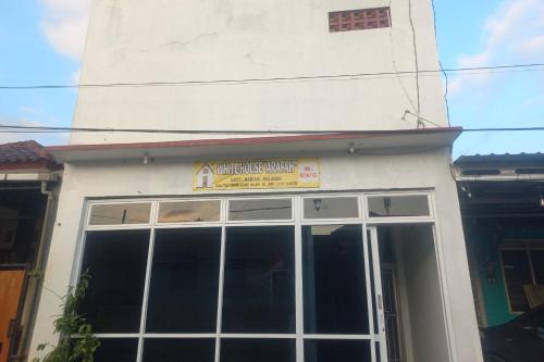 a building with a large window with a sign on it at OYO 94771 White House Arafah Syariah in Purwokerto