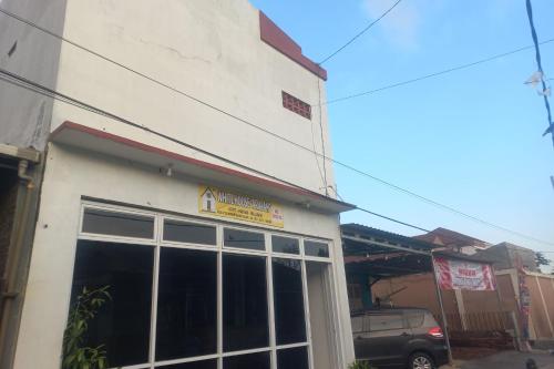 a building with a sign on the side of it at OYO 94771 White House Arafah Syariah in Purwokerto
