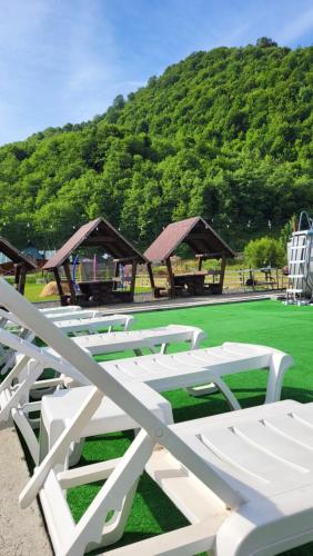 a group of white chairs sitting on a grass field at Котеджі Карпати Fest in Mizhhirʼʼya