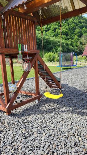 a playground with a swing and a playground at Котеджі Карпати Fest in Mizhhirʼʼya