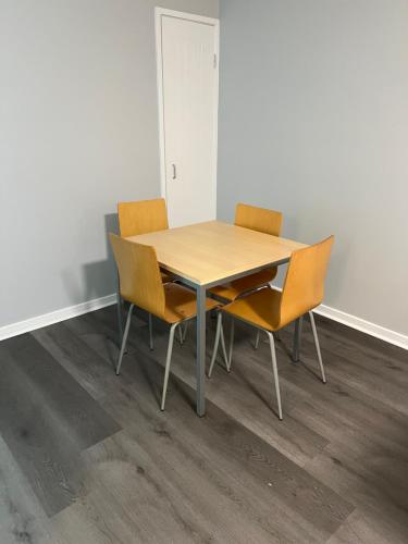 a wooden table and chairs in an empty room at Caloundra Central Apartment Hotel Official in Caloundra