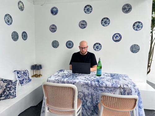 a man sitting at a table with a laptop at Bintana Sa Paraiso in Mambajao