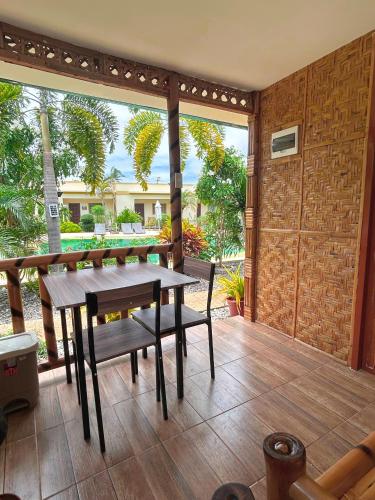 a patio with a wooden table and a bench at Imagine Bohol in Panglao