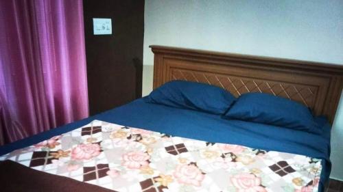a bed with a blue comforter and blue pillows at 7th Heaven Kannur in Kannur