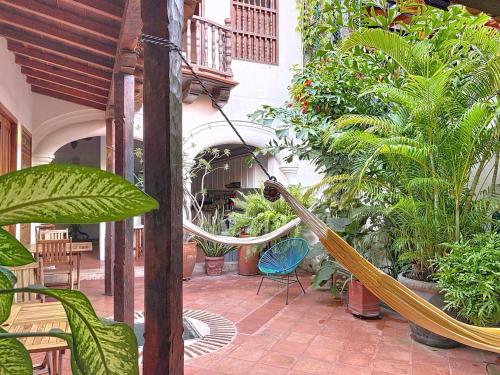 a hammock in the middle of a courtyard with plants at Casa Digna in Cartagena de Indias