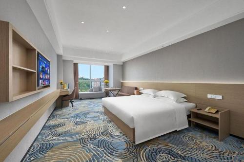 a bedroom with a large bed and a large rug at Grand Nest Hotel (Tang Jia Wan Beach) in Zhuhai