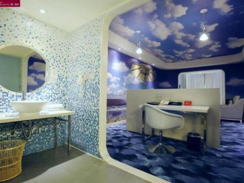 a bathroom with a sink and a vanity with a mirror at Grand Nest Hotel (Tang Jia Wan Beach) in Zhuhai