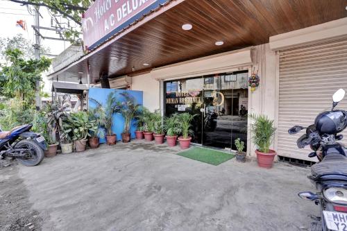 a motorcycle parked outside of a store with potted plants at Hotel O Dhiman Residency in Mumbai