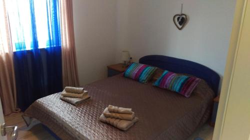 a bedroom with a bed with two towels on it at Apartment Casa Eni in Dražice