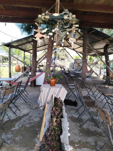 a patio with a table and chairs and a chandelier at Eco Camping - Home-tent in Can Gio