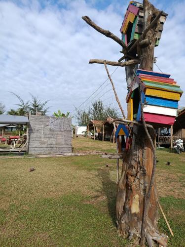 a tree with a colorful bird house on it at Eco Camping - Home-tent in Can Gio