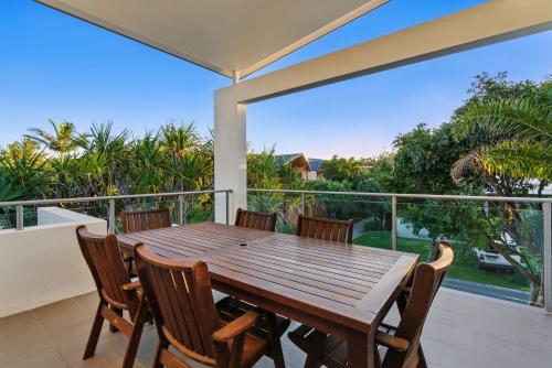 a wooden table and chairs on a balcony at 48 Boardrider Crescent in Marcoola